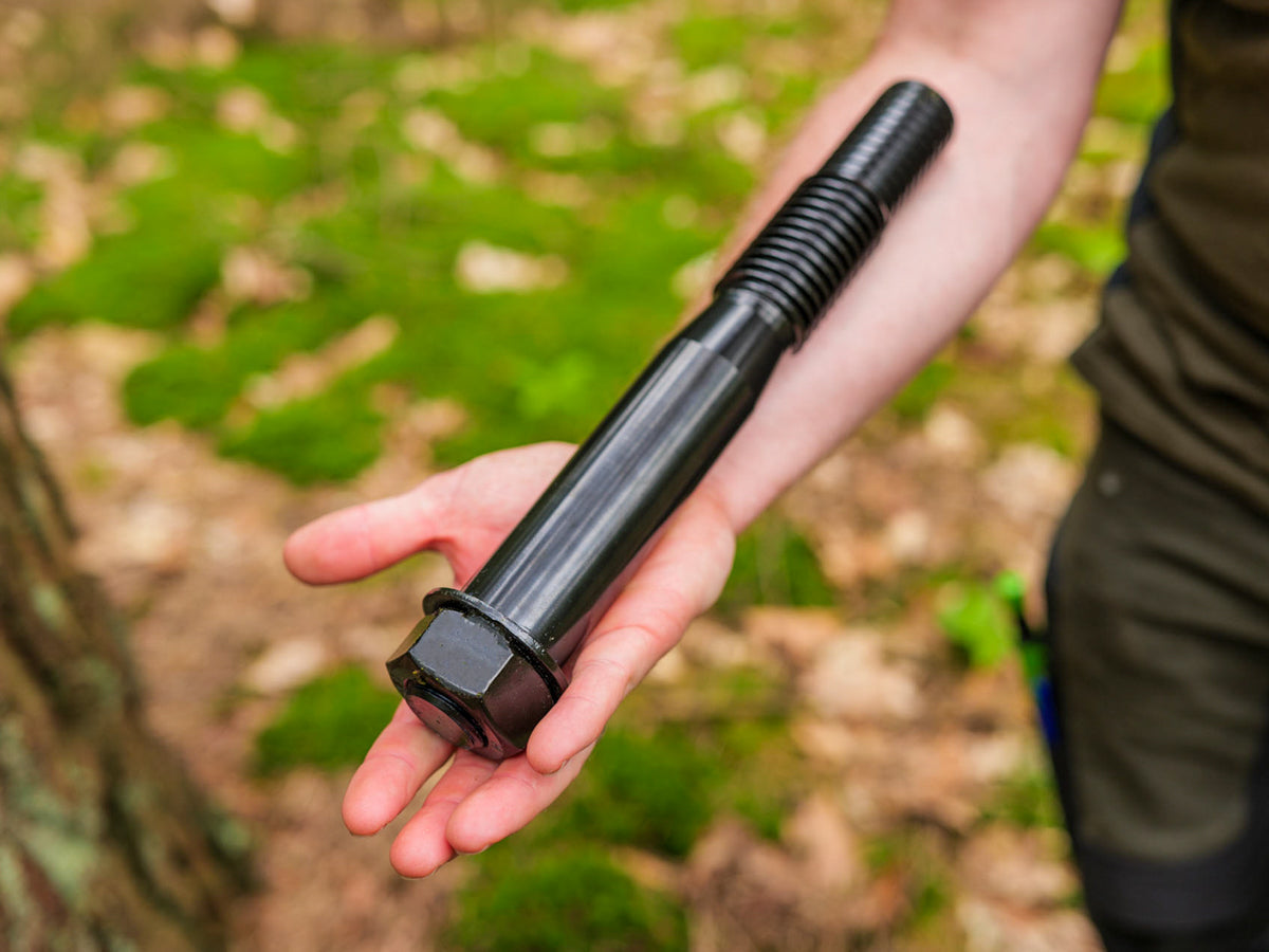 Mann hält große Baumschraube im Arm - German Treehouse Screw – Tree Attachment Bolt