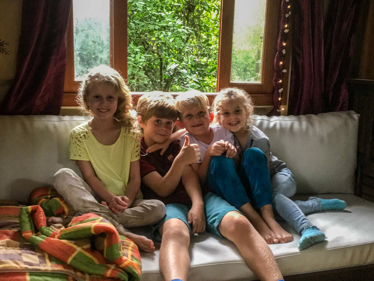 Glückliche Kinder sitzen im Baumhaus - Daumen hoch!